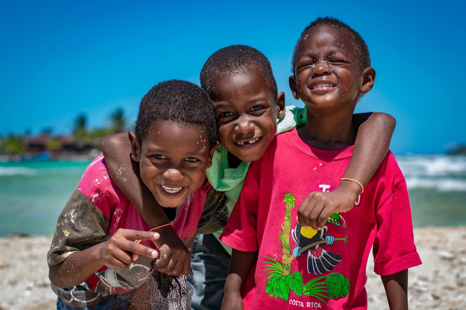 Three children laughing on a beach